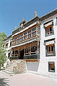 Ladakh - Sankar gompa (Leh), the main monastery halls with the characteristc red painted windows and woden balconies on white washed faades 